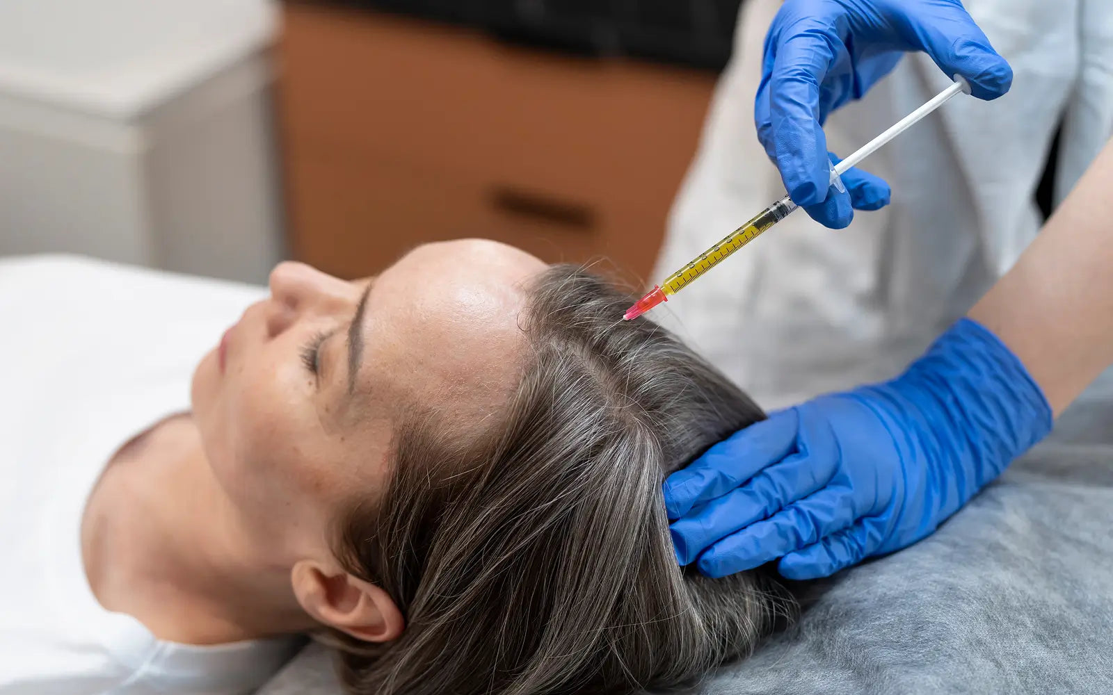 Image of a medical professional injecting PRP into a client's scalp.